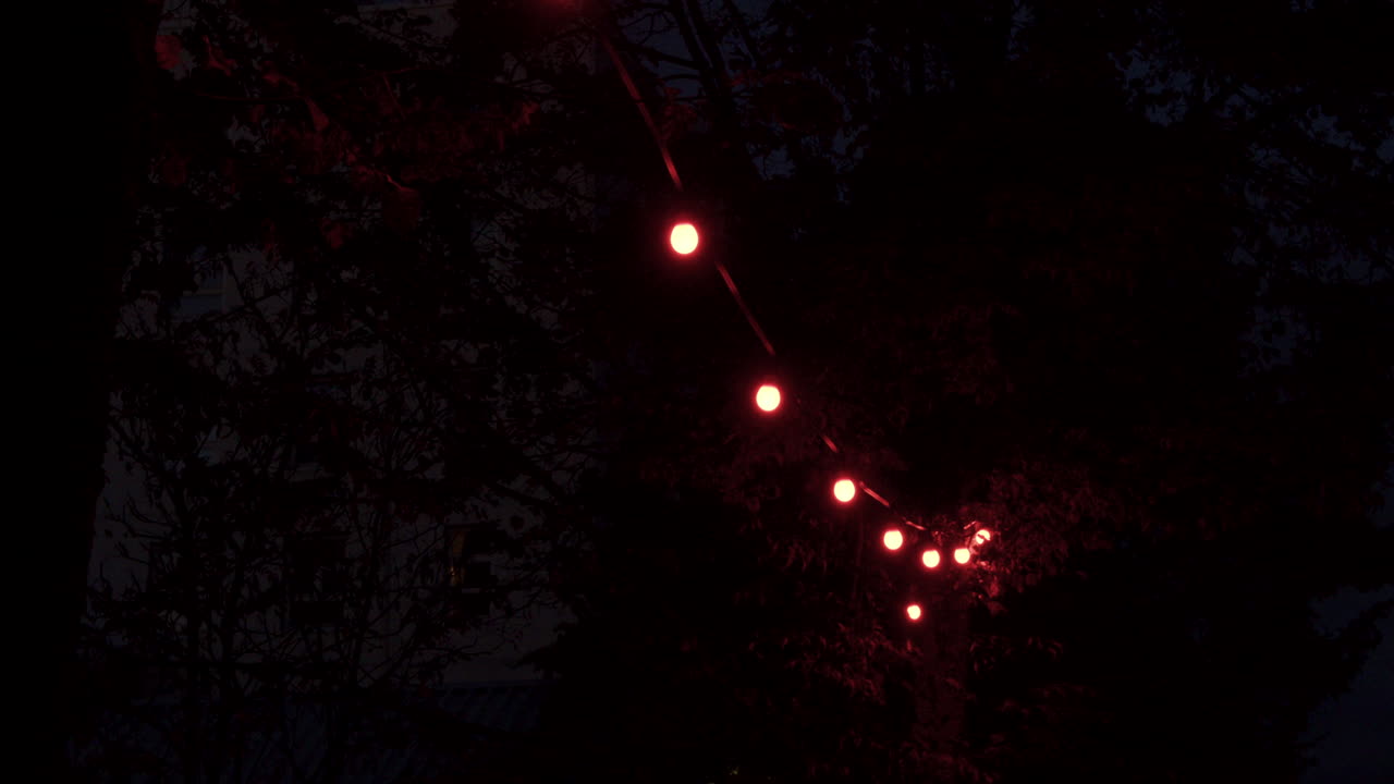 우울한 분위기를 주는 매우 희미한 빨간 전구의 패닝 샷