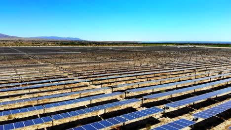 Solar-panel-photovoltaic-farm-aerial-4k-drone-rise-above-huge-array-of-panels-with-Salton-Sea-in-distance