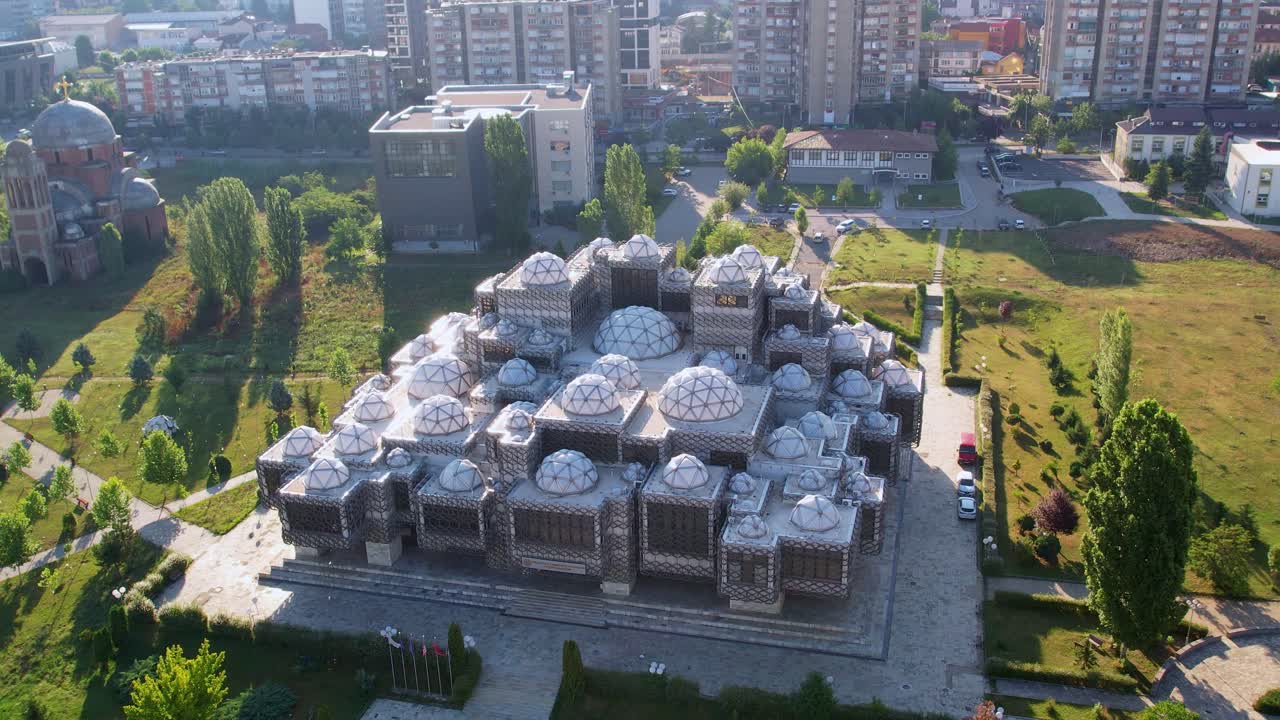 foto aérea de un parque en pristina, kosovo con una biblioteca brutal y una iglesia ortodoxa serbia