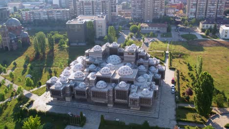 Aerial-of-park-in-pristina,-Kosovo-with-brutal-library-and-serb-orthodox-church