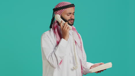 un árabe habla por teléfono fijo.