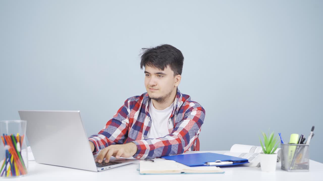 노트북을 바라보는 남자가 긍정적인 몸짓을 합니다.