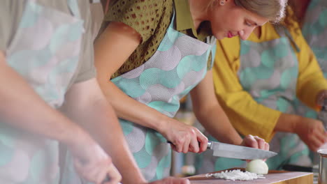 woman learning how to chop onion during cooking master class