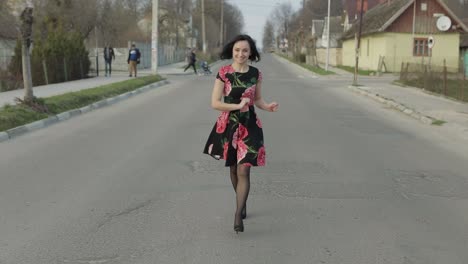 Una-Joven-Atractiva-Con-Un-Vestido-Con-Flores-Caminando-Por-La-Carretera.