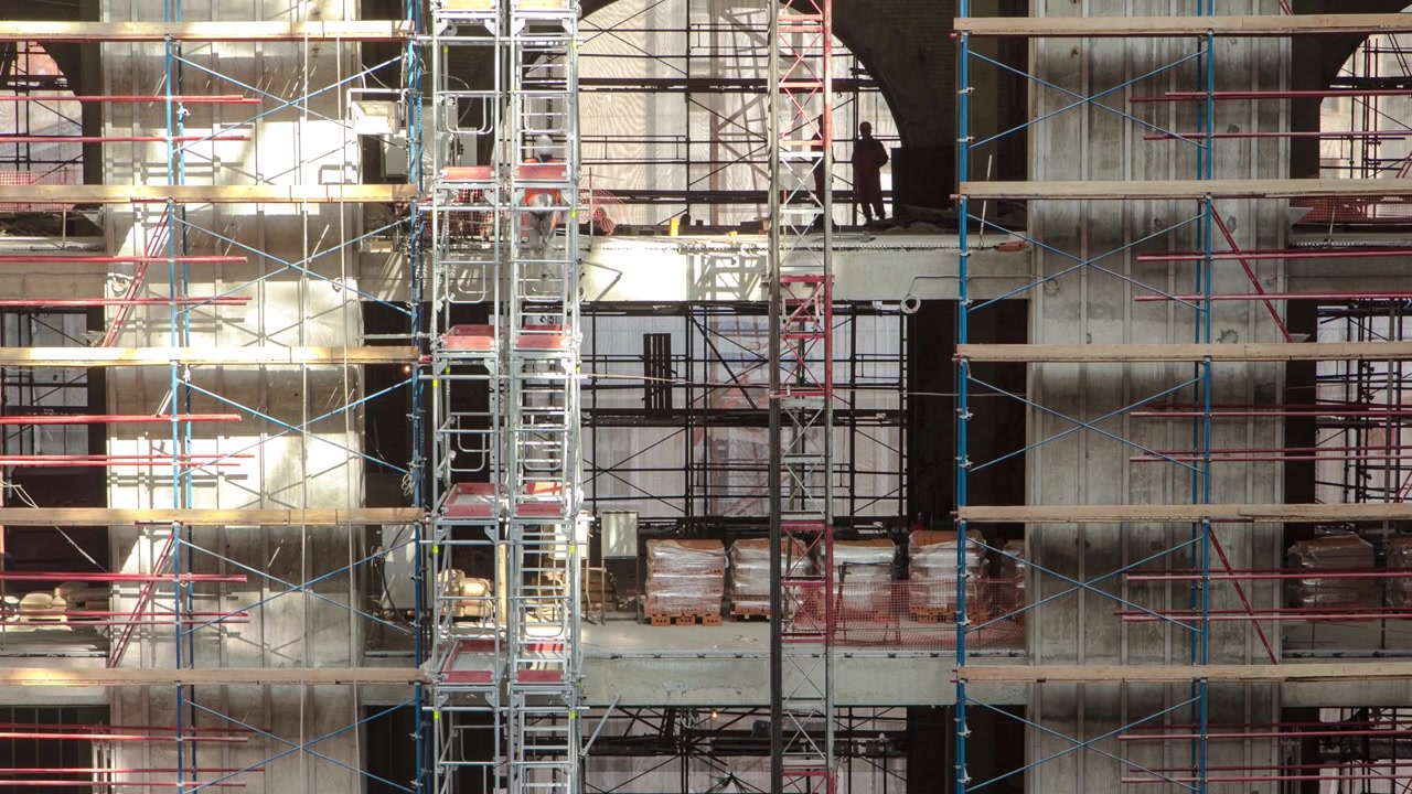 Construction equipment material with scaffolding and tools inside the floor of high rising building timelapse, skyscraper. Building under construction. Interior work between floors in progress