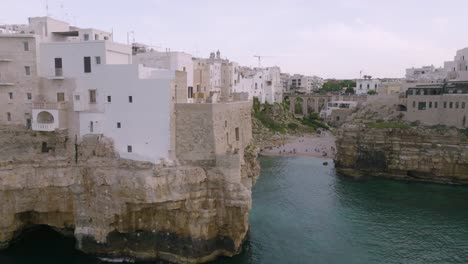 Slow-aerial-reveal-of-Lama-Monachile-beach-in-Polignano-a-Mare,-Italy