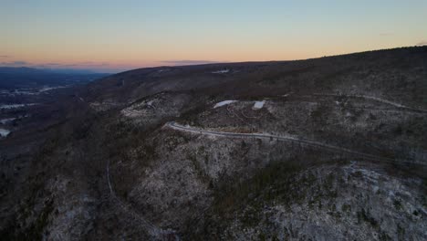 Imágenes-Aéreas-De-Drones-De-Una-Hermosa-Carretera-Escénica-Nevada-En-Las-Montañas-Apalaches-Durante-El-Invierno-Al-Atardecer-Con-Una-Hermosa-Luz