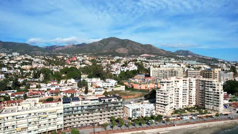 aerial reverse dolly reveals fuengirola hills and large mountain