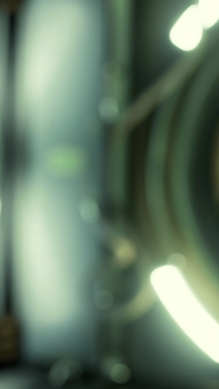 Light beams shine in a circular design with blurred details in a dark space
