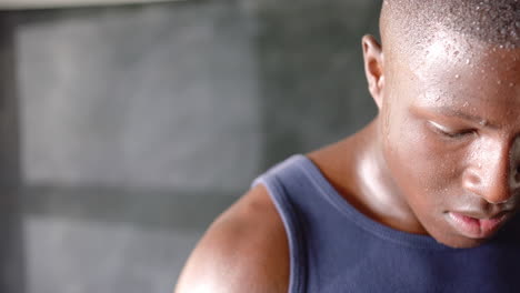 sweating and focusing, african american man in tank top exercising intensely in gym, copy space