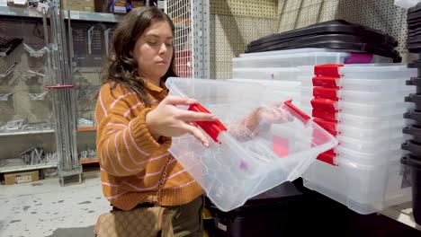 woman choosing storage boxes in hardware store