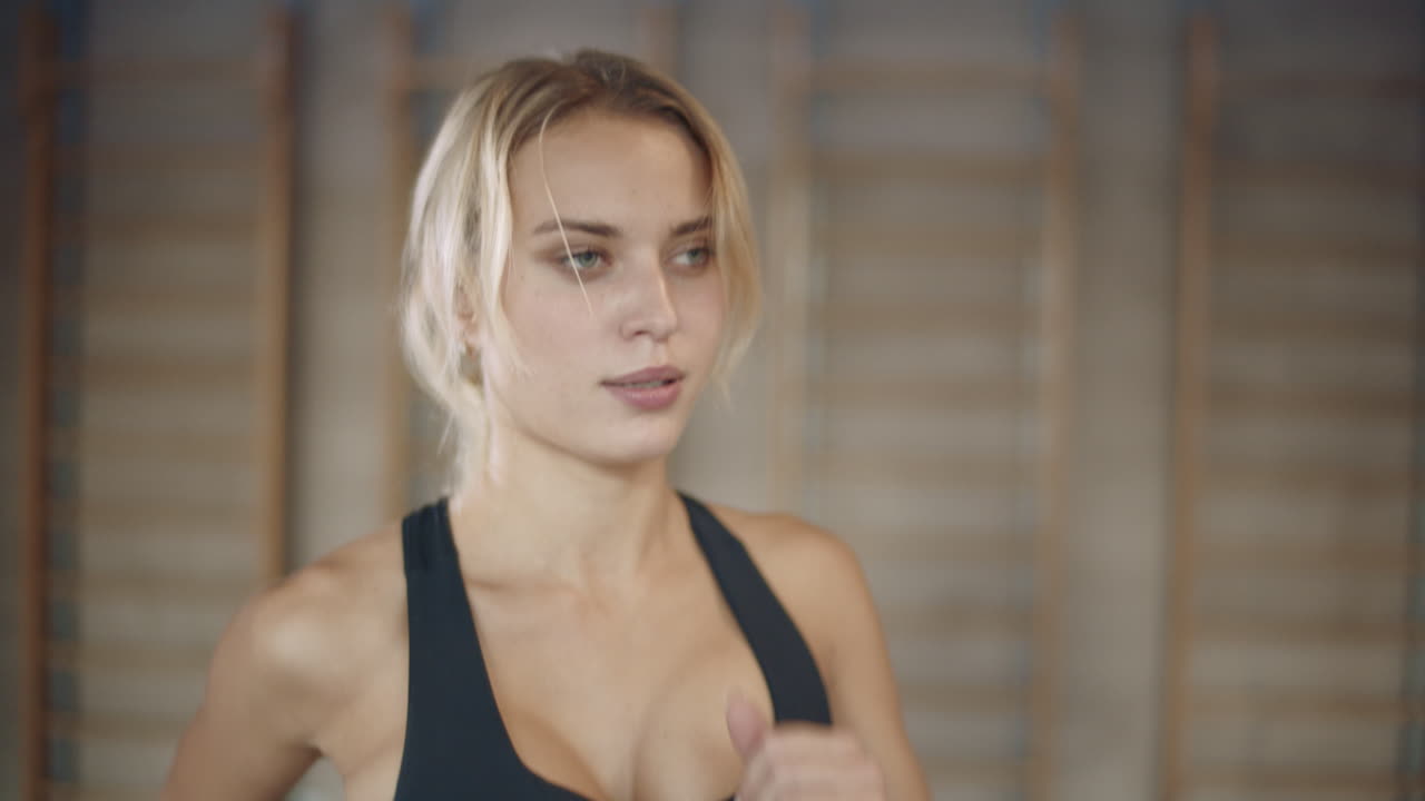 retrato de una mujer bonita corriendo en una máquina de caminadora en un club de fitness.