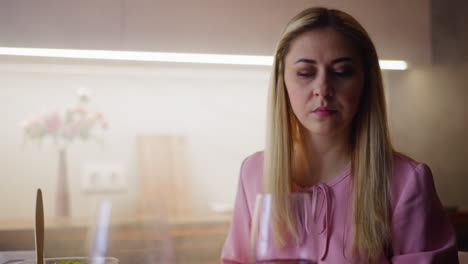 upset woman looks at glass with wine suspecting poisoning