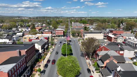 Aufsteigende-Drohne-Erschossen-Amerikanische-Stadt-Mit-Wehender-Flagge-Der-USA