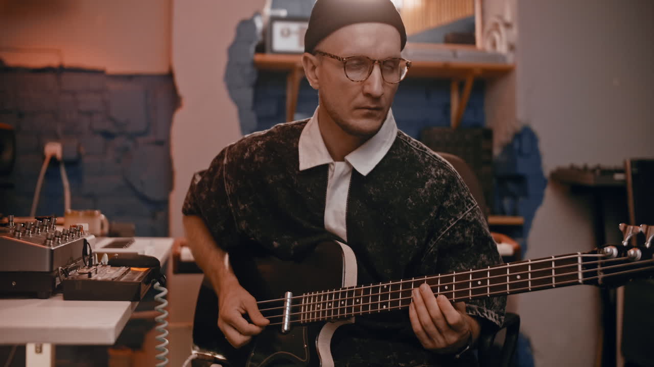 Musician Playing Bass Guitar in Recording Studio