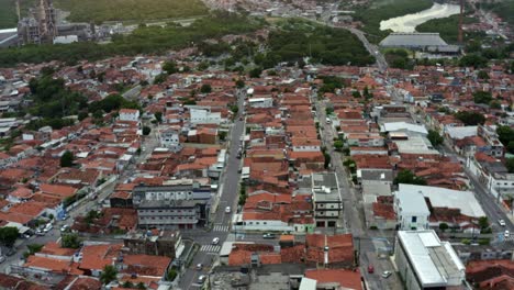 Truck-left-aerial-drone-shot-of-historic-neighborhood-streets-in-the-old-downtown-of-the-tropical-coastal-capital-city-of-Joao-Pessoa,-Paraiba,-Brazil-with-homes,-stores,-and-factories-during-sunset