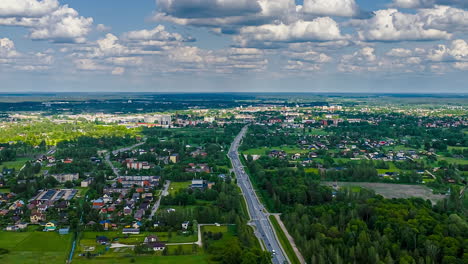 a vista of town and road traffic set in dense rural nature. hyperlapse