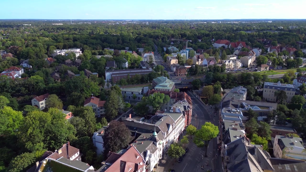 Sobborgo di Berlino Zehlendorf che mostra edifici e la stazione ferroviaria della S-Bahn in una soleggiata giornata estiva. Incredibile veduta aerea con drone.