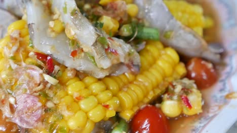 thai style spicy corn salad with raw shrimp, close up