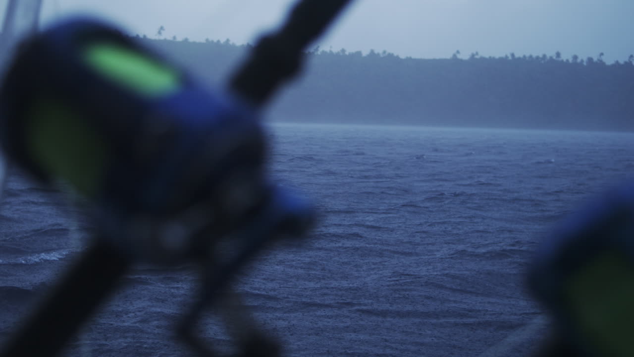 Rainy ocean backdrop with blurred equipment in foreground amid storm motion