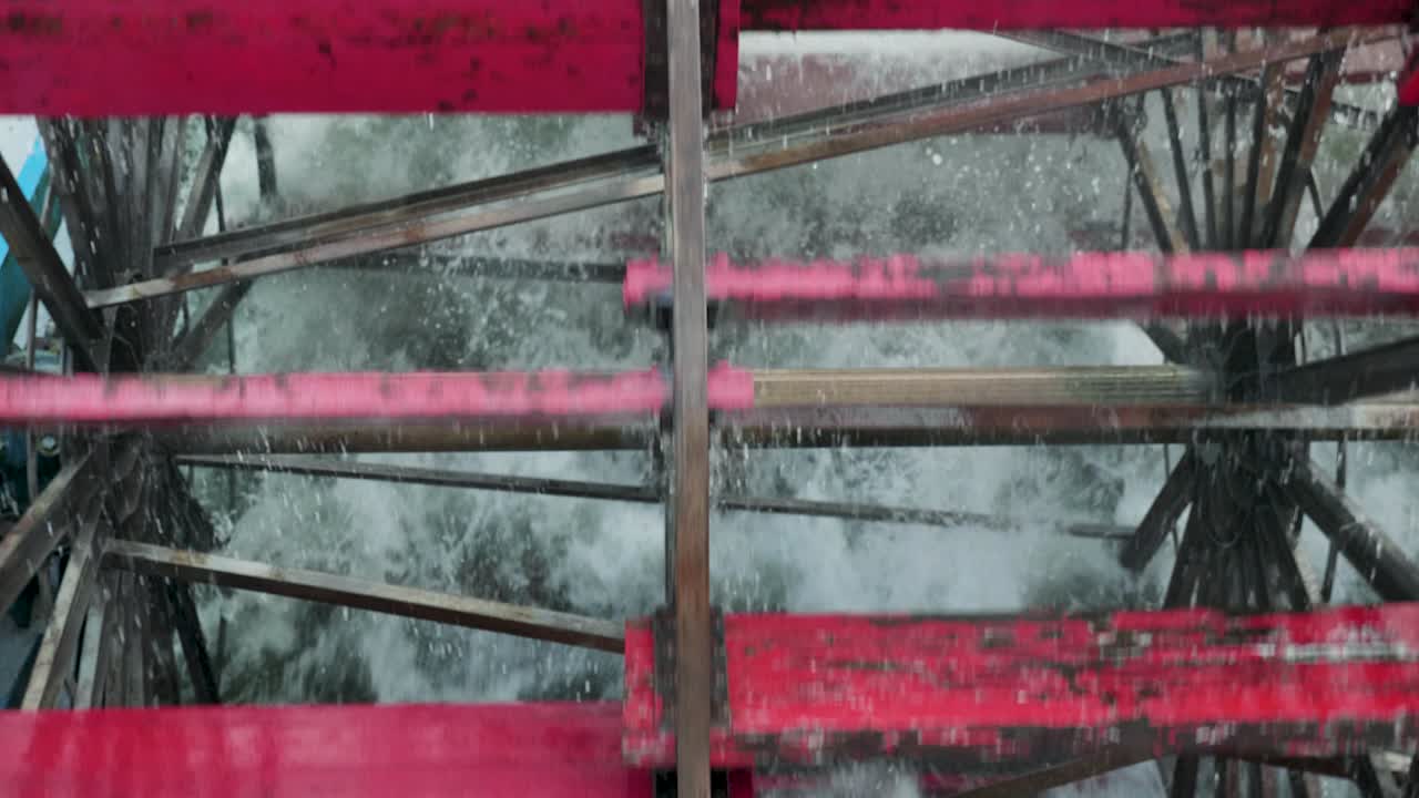 Wheels of Sternwheeler old fashioned ship turning with red paddles in the river splashing the water close up slow motion