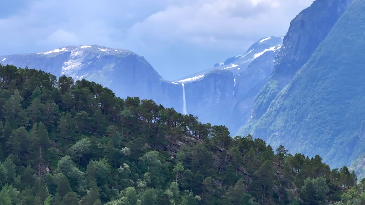 el dron se eleva lentamente detrás de las montañas y mardalsfossen en eikesdal aparece a la vista