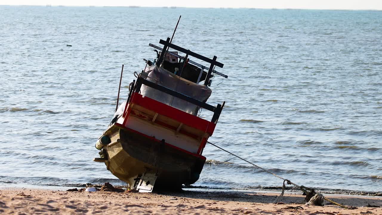 barco anclado en una playa de arena junto al mar