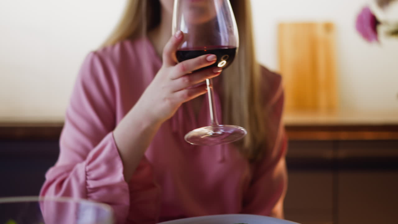 Mujer con ensalada bebe delicioso vino sentada a la mesa