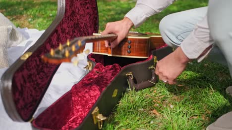 un marito che apre una custodia per la chitarra al cherry blossom park di washington dc durante un picnic di famiglia