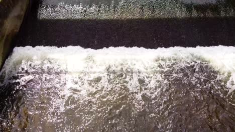 Luftaufnahme-Von-Oben-Nach-Unten-In-Zeitlupe-Eines-Kleinen-Staudamms-Am-Little-Ouse-River-In-Der-Nähe-Von-Thetford-In-Großbritannien