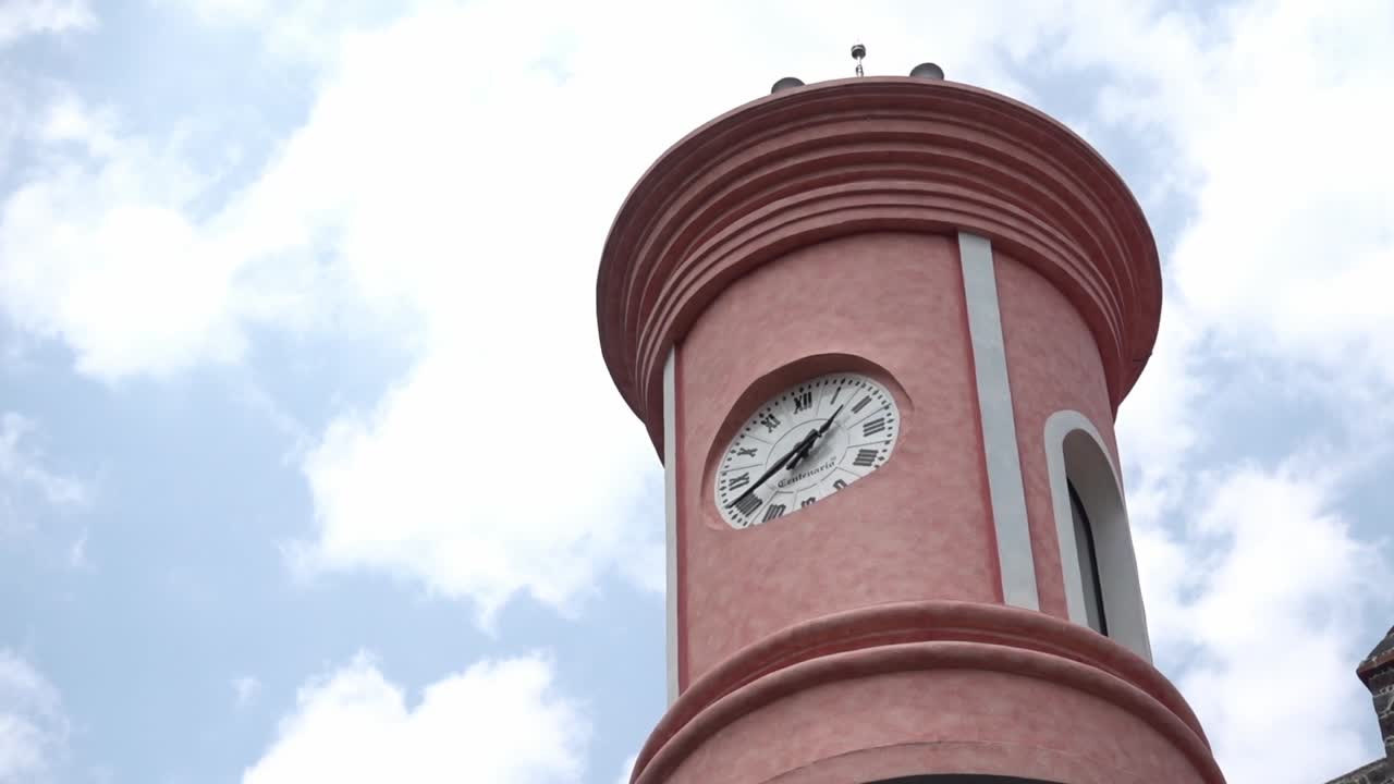 A clock in a tower that belongs to the Palace of Cortes museum