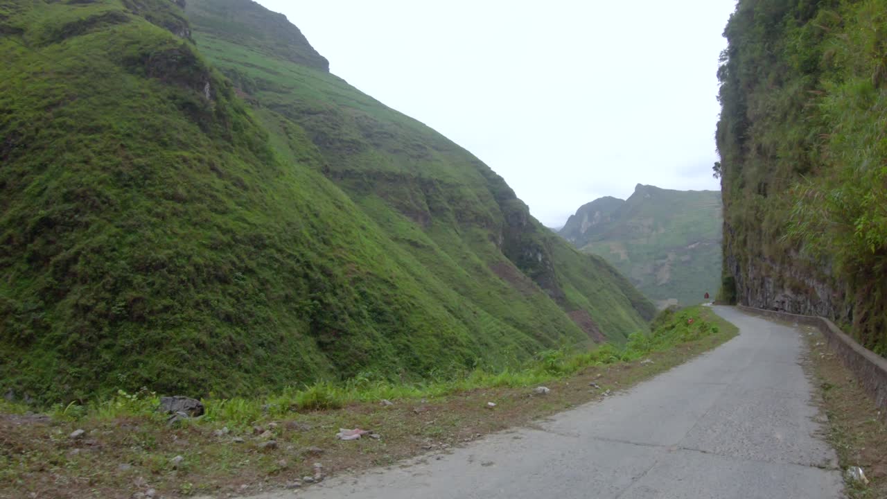 вид от первого лица на узкую извилистую неровную дорогу, проходящую через горы и долины северного вьетнама