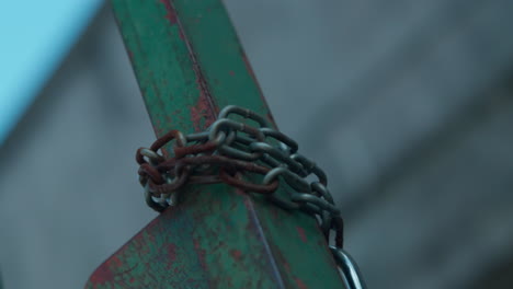 iron rusty chain wrapped around a green post