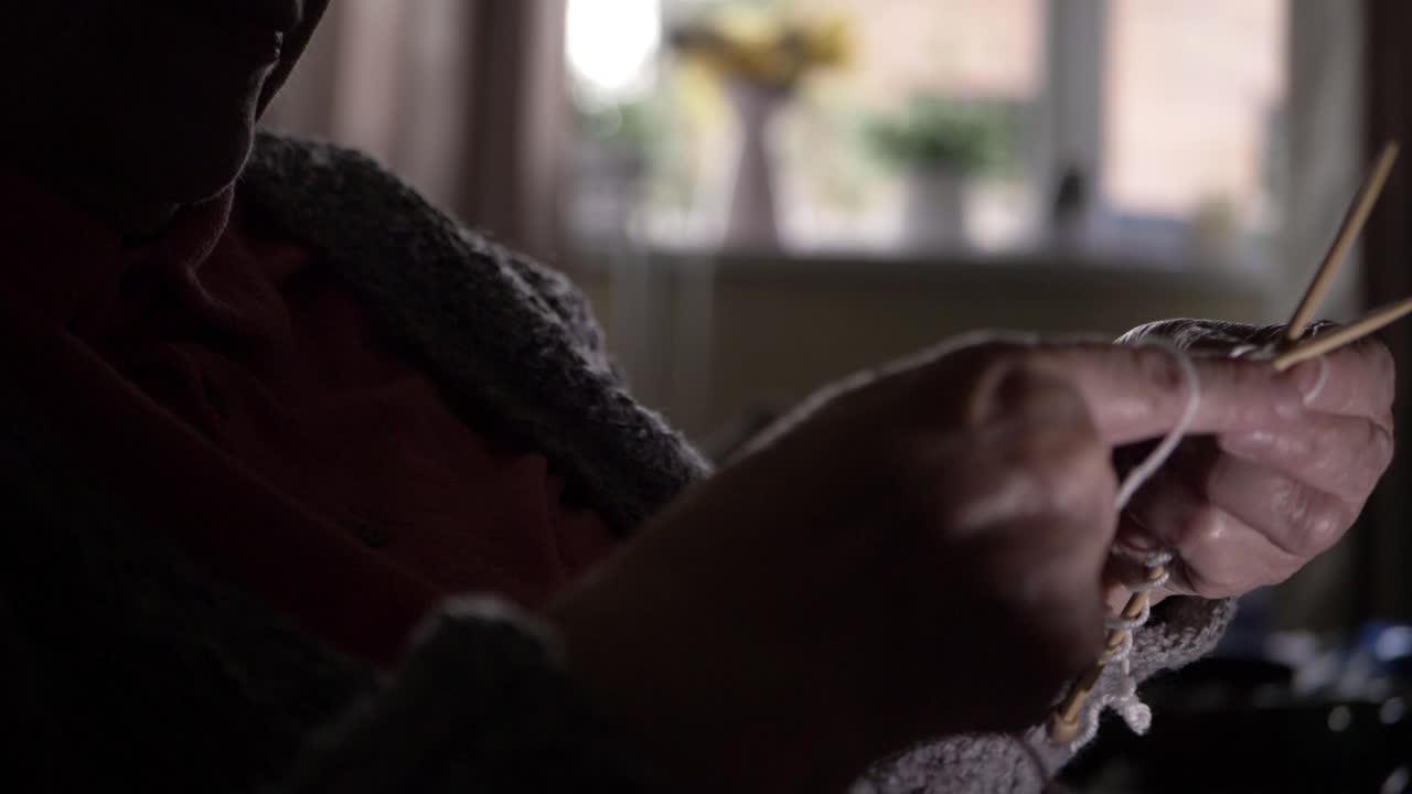 anciana sentada en casa tejiendo plano medio