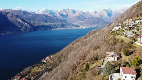 Casas-De-Montaña-En-La-Ladera-Y-Majestuosa-Vista-Panorámica-Del-Lago-Como,-Vista-Aérea