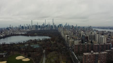 Soar-over-the-iconic-Central-Park-in-the-heart-of-New-York-City,-revealing-the-green-oasis-nestled-amidst-the-bustling-urban-environment