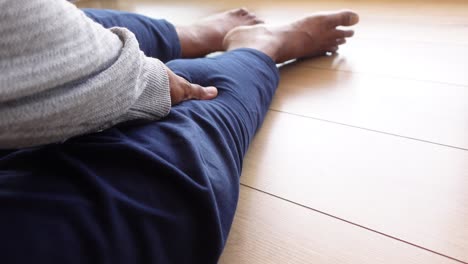 person sitting on the floor with hand on leg