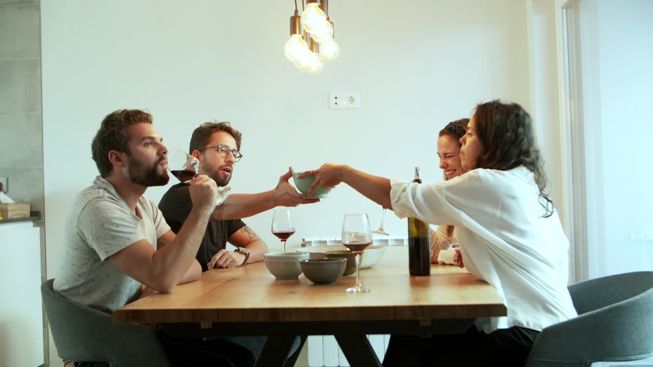 Cena em câmera lenta de amigos conversando enquanto bebem vinho tinto