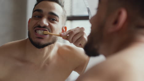 hombre cepillándose los dientes en el baño
