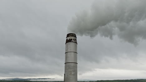 aerial orbit around factory smokestack emitting hazardous gases into atmosphere