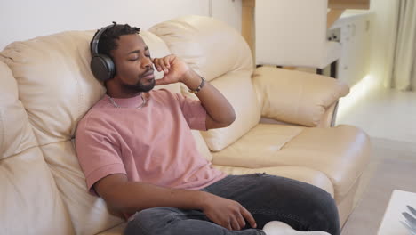 man relaxing on sofa with headphones