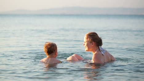 mother playing with her young son in the sea