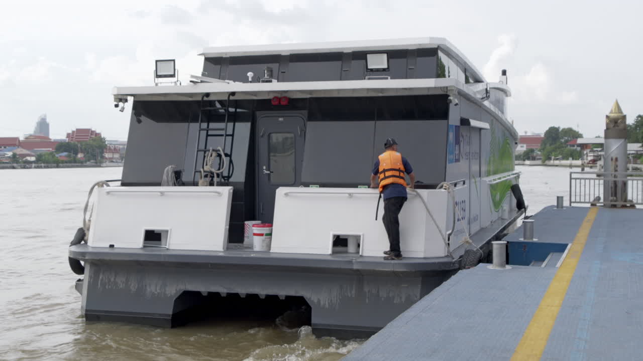 Eco-friendly electric speedboat departing from the dock after transporting passengers on the Chao Phraya River in Bangkok, showcasing sustainable urban transportation solutions.