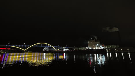 Buque-De-Carga-Moviéndose-Bajo-El-Puente-Conmemorativo-De-Daniel-Hoan,-Noche-En-Milwaukee,-Estados-Unidos