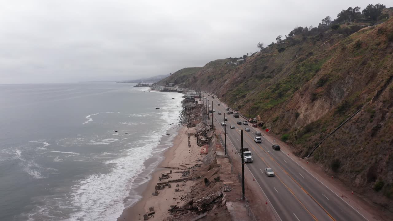 Aerial close-up shot flying over burned beachfront homes along Pacific Coast Highway after the Palisades Fire in Malibu, California. 4K