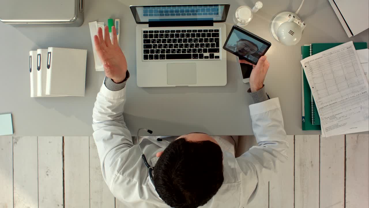 médico hablando por video con su colega senior en la tableta. vista superior