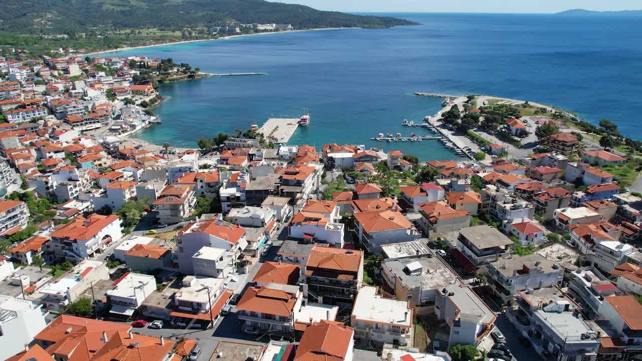 4K aerial drone footage of Neos Marmaras in Sithonia, Halkidiki, Greece. Scenic views of the seaside town, marina, turquoise sea, and beach—ideal for travel and tourism content