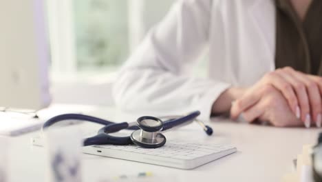 doctor's hands with stethoscope and keyboard