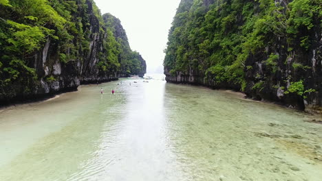 Dolly-In-Der-Luftaufnahme-Des-Klaren-Wasserdurchgangs-Zwischen-Zwei-Bergen-In-Palawan,-Philippinen