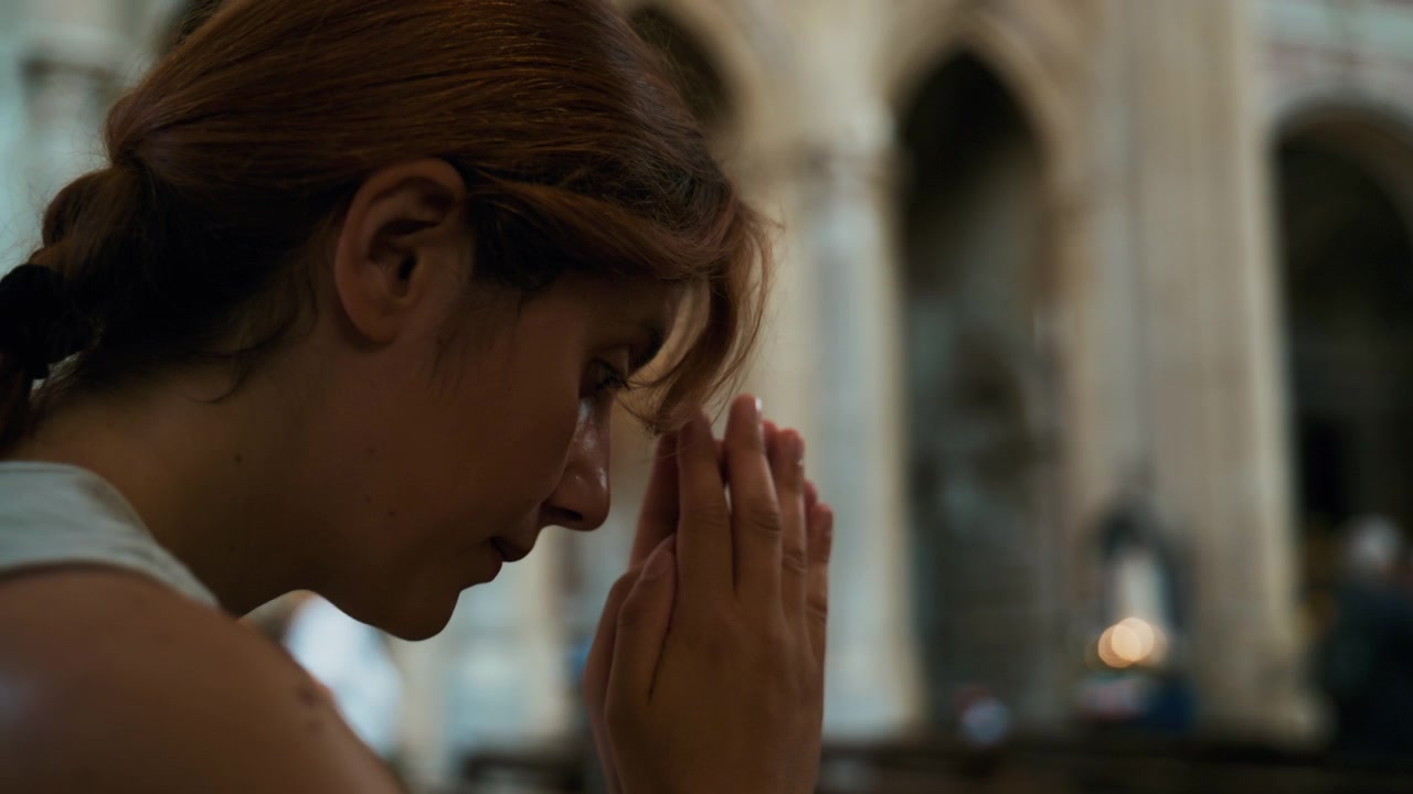 Silhueta de uma mulher em profunda oração silenciosa em uma igreja